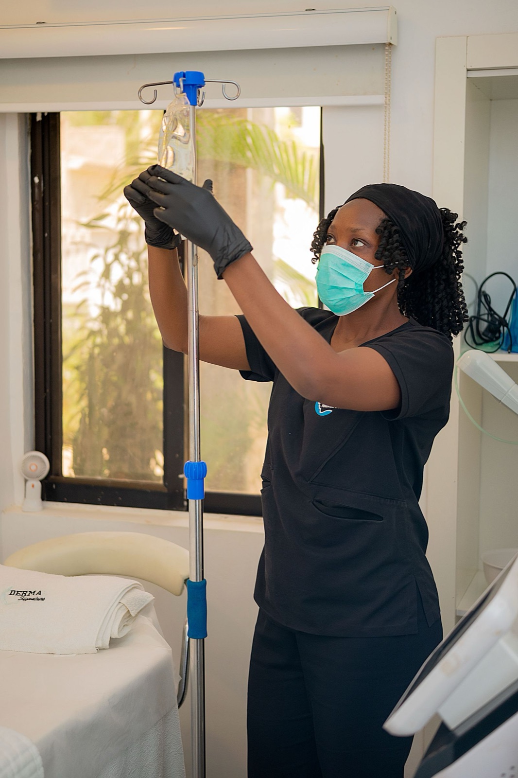 Clinician adjusting an IV drip in a treatment room